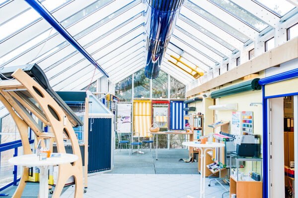 Heller Ausstellungsraum mit modernen Markisen, Sonnenschutz-Systemen und Farbmusterkarten.